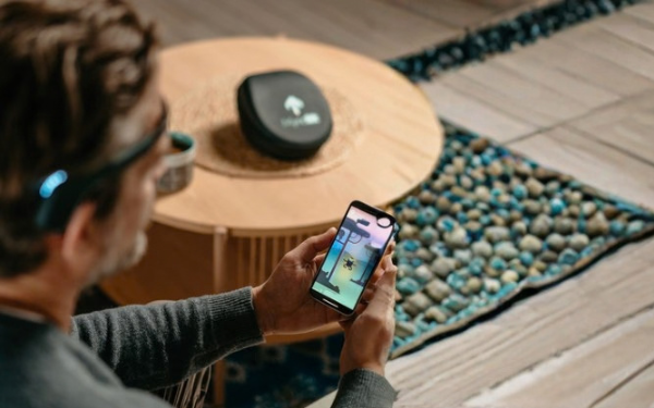 man using myndlift neurofeedback headset and playing game on phone